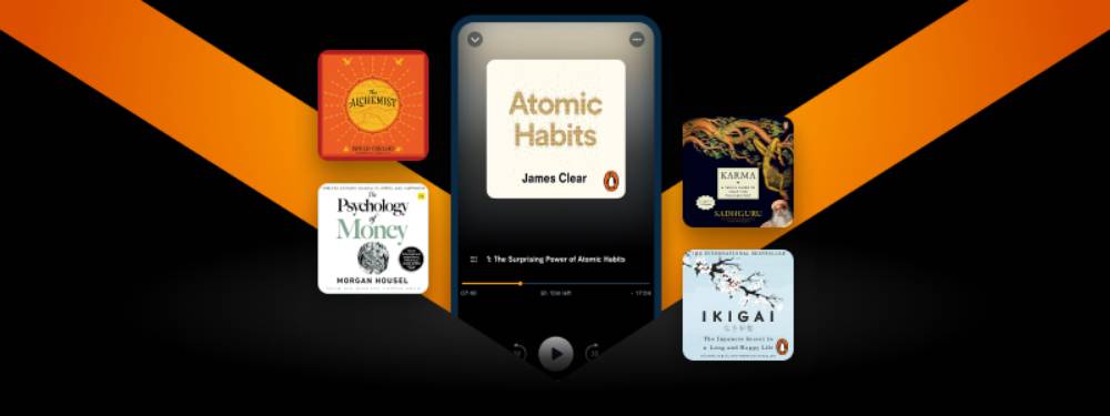 Digital display featuring the audiobook 'Atomic Habits' by James Clear, surrounded by covers of other popular titles like 'The Alchemist' and 'Ikigai'.