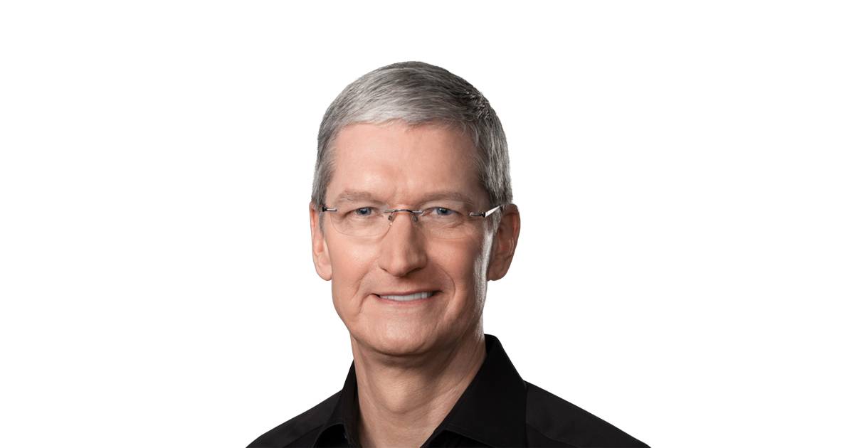A man with short gray hair and glasses wears a black shirt; he is facing the camera with a neutral expression against a white background.